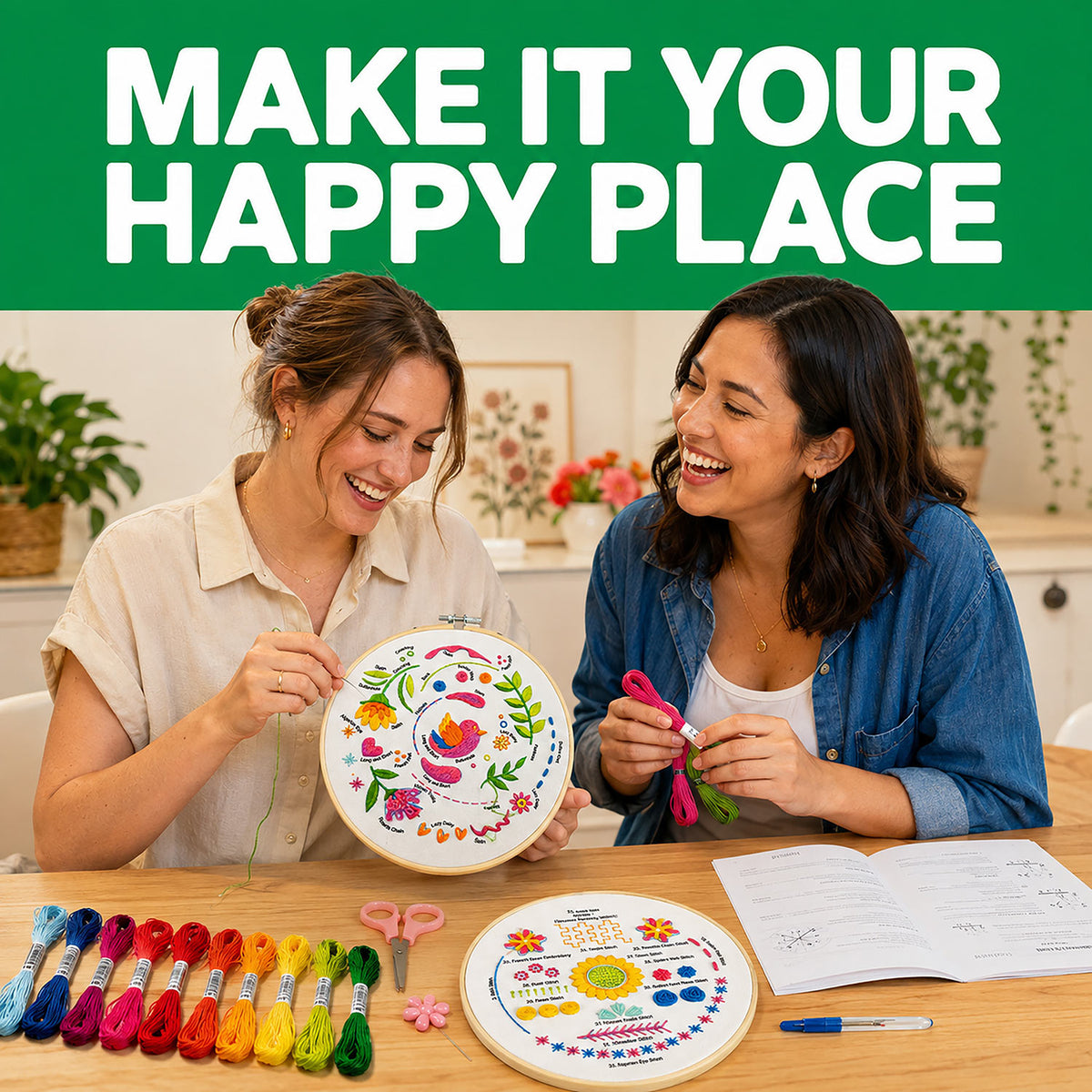 Two women smiling at a table with embroidery hoops, colorful thread skeins, scissors, and a printed pattern. A green banner at the top reads 'MAKE IT YOUR HAPPY PLACE'.