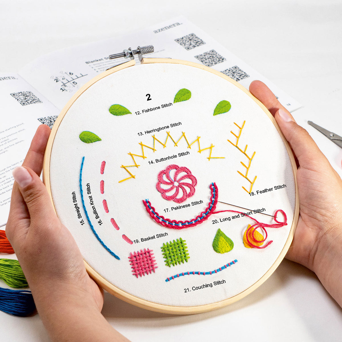 Embroidery hoop with various stitches demonstrated on a white background